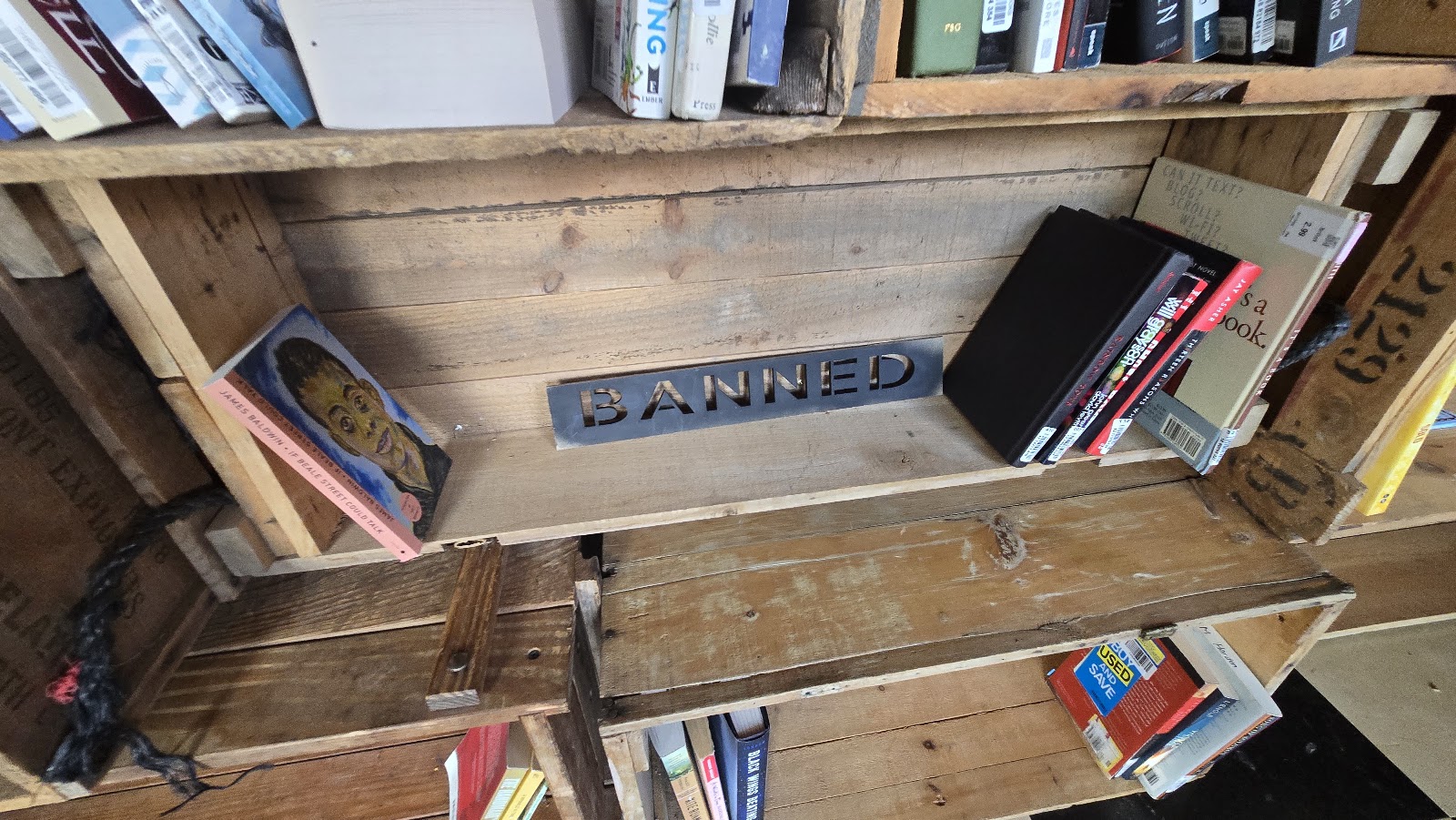 A low shelf carved with the word BANNED, a handsaw hanging above it