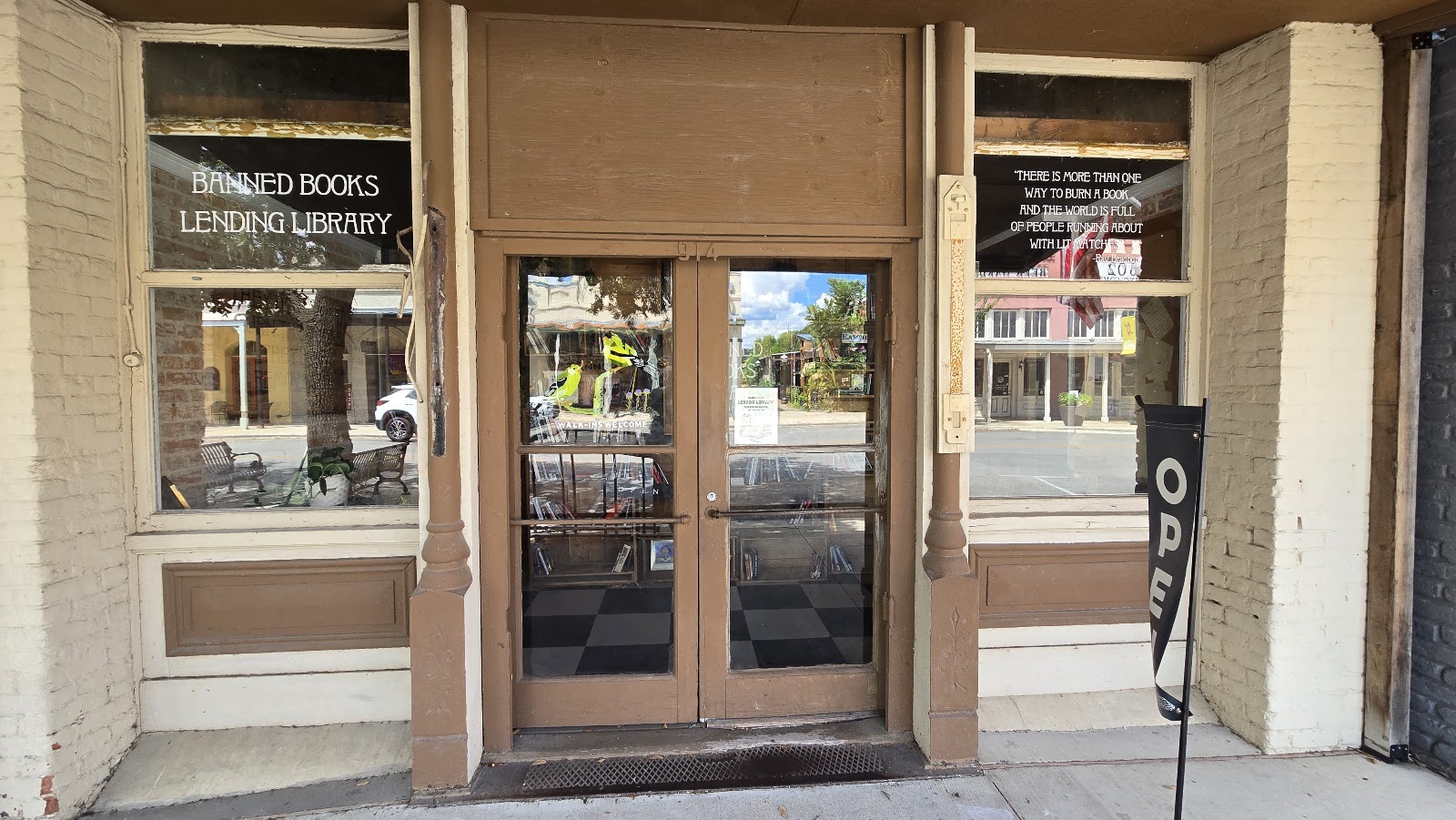 The Painted Porch storefront in Bastrop, its window etched 'Banned Books Lending Library'